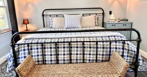 Queen sized bed with plaid sheets at Sandy Bay Lakehouse