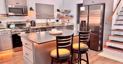 Kitchen at Sandy Bay Lakehouse with grey cabinets and large stainless steel fridge