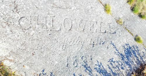 An old carving of a name in a stone from the 1800s.