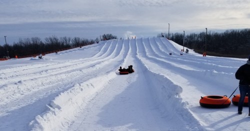 Speeding down groomed snow tubing lanes on a bright, sunny winter day. Perfect family adventure.