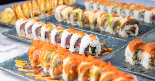 several plates filled with all kinds of sushi rolls at. sushi king in New Mexico