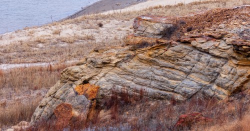 Layered rock formations on the shoreline of Wilson Lake at Lucas Park Recreation Area in Lucas, Kansas.