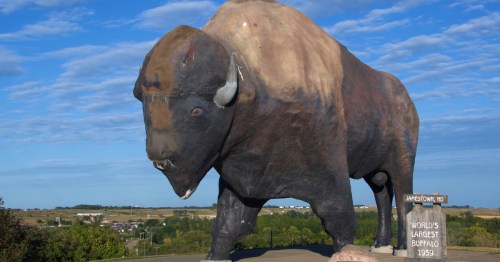 World's Largest Buffalo monument at the National Buffalo Museum in Jamestown, North Dakota, under a blue sky.