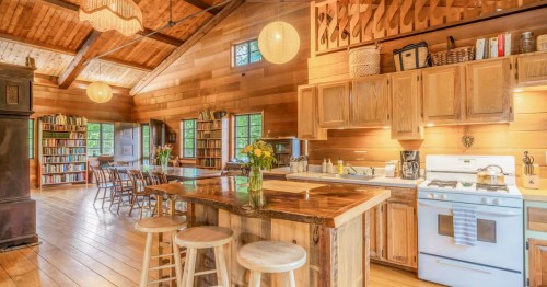 The open concept kitchen area at the Alpine-style AIrbnb, The Chalet in Nelson, New Hampshire. Wooden decor is pictured throughout the room.