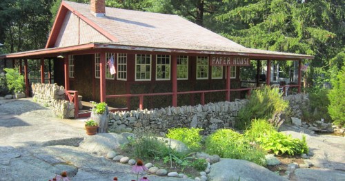 A sunny view of the outside of Rockport, MA's Paper House, a home largely constructed from newspaper.