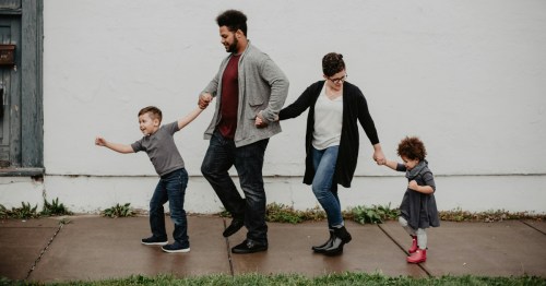 A happy family walking together down a sidewalk, highlighting the community lifestyle found in Maryland.