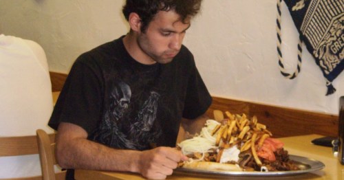 A young man faces a mountain of meat and fries at Greek Village Grille in Lakewood, Ohio.