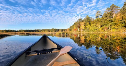 A kayak on a lake in fall near the Hayward Haus in Hayward, Wisconsin which looks like a dupe of a cabin in Scandinavia