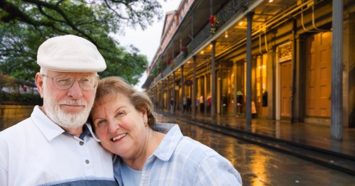 a retired couple poses for a photo on a street in Louisiana