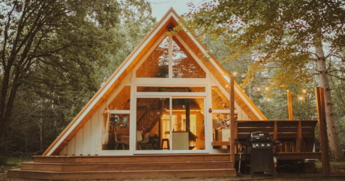 The modern A-frame cabin known as Stylle Hytte in Brook Park, Minnesota, features a large glass façade and wooden deck, offering a cozy retreat that feels just like being in Norway.