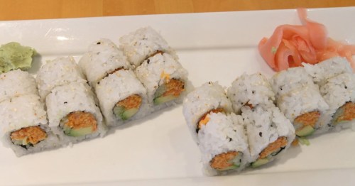 a white plate with two sushi rolls