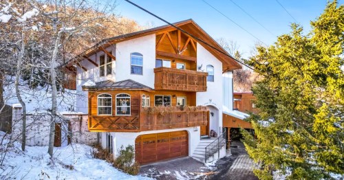 A German-style Airbnb chalet in Utah, featuring wood finishes and steep roof, surrounded by snowy landscapes.