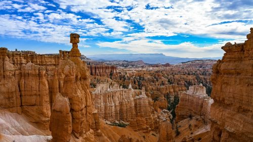 A stunning view of Bryce Canyon's unique rock formations under a blue sky with scattered clouds.
