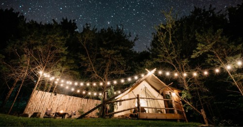 A tent site at Ozark Mountain Adventure at night under a starry sky
