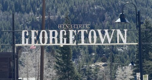 Historic Georgetown sign against a backdrop of evergreens.