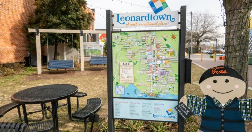 A small town square with a town map reading "Leonardtown" and a cardboard cutout figure smiling next to it.