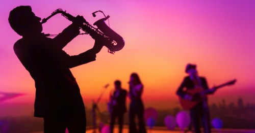 The silhouette of a band with a man playing the saxophone.