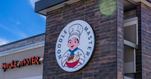 The exterior of Noodle Master in Texas, featuring a logo of a chef holding a bowl of noodle soup.