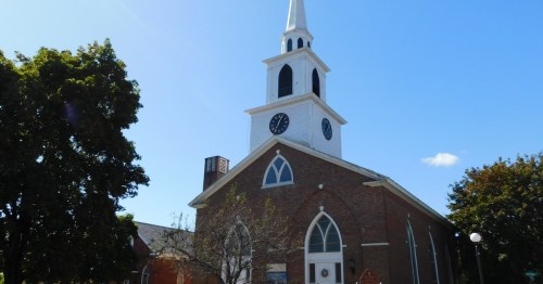 A historic church against a blue sky in Brandon, VT