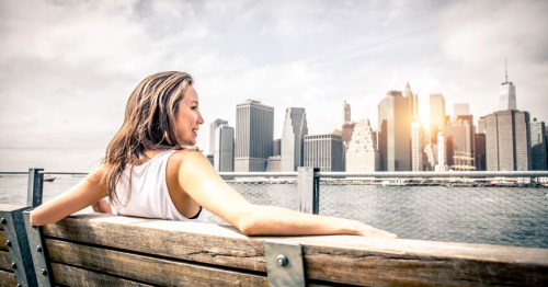 A female solo traveler in New York City admiring the skyline.
