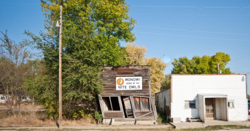 The Monowi Tavern and a weathered wooden building home to the Nite Owls in Monowi, Nebraska.