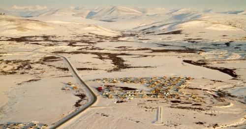 Small villages blanketed in snow stretch out over an arctic tundra.