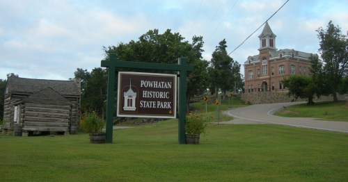 sign for powhatan historic state park with the town's historic courthouse in the background