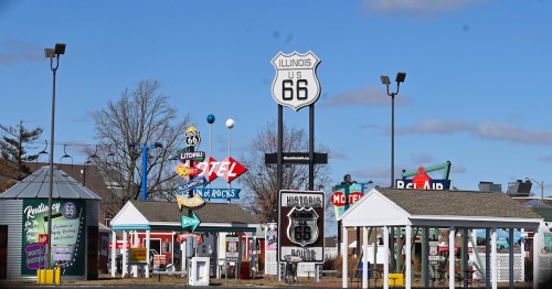 Historic neon signs and town markers at the Route 66 Experience roadside attraction in Springfield, Illinois.