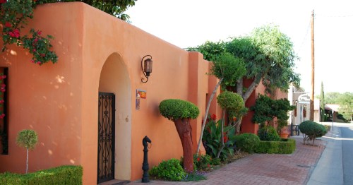 A brick walkway passes classic adobe homes near Mesilla Plaza in New Mexico.