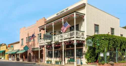 The historic National Hotel along Main Street in Jamestown, California, with balcony and American flags.