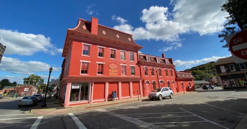 Vibrant red historic brick building in downtown Lisbon, Ohio under a blue sky.