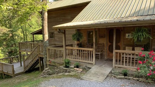 A rustic wooden cabin with a porch, surrounded by greenery and flowers, set in a peaceful outdoor environment.