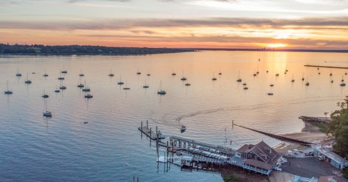 A sunset view of a marina off Glen Cove in Long Island, with a view of the boats on the water.