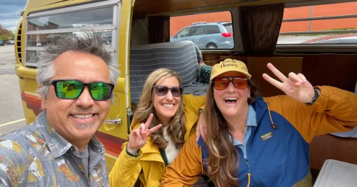 A guide and two tour guests stand in front of the vintage VW Nachobus along the Sample Craft Breweries in a Vintage VW Bus tour in Portsmouth, New Hampshire.