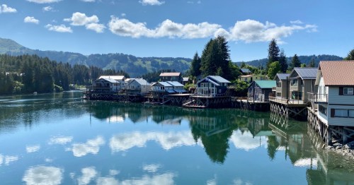 Colorful homes sit along clear and calm water in Seldovia, Alaska.