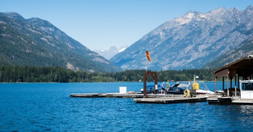 Several people stand along a dock in Lake Chelan, near the lesser-known small town of Stehekin, Washington.