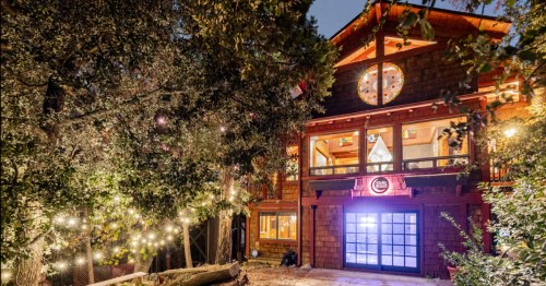 The exterior of the Faerie House, a unique Airbnb in Southern California, all lit up at night.