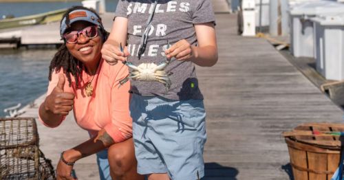 Tia Clark next to a crabbing customer in Charleston, South Carolina