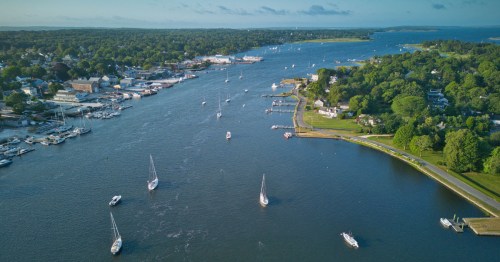 An aerial view of the Warren River and the historic waterfront district in Warren, Rhode Island, on a clear day.