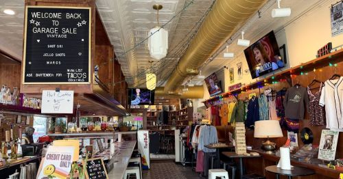 A U-shaped bar surrounded by vintage clothing racks