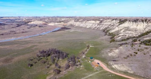 Overhead drone shot of a secluded log cabin nestled in the Badlands near Medora, ND.