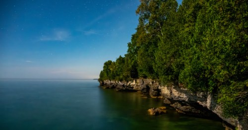 Twilight sky filled with stars at Cave Point County Park in Door County, Wisconsin