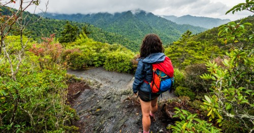 Woman hikes by beautiful cloudy overlook in the Great Smoky Mountains National Park