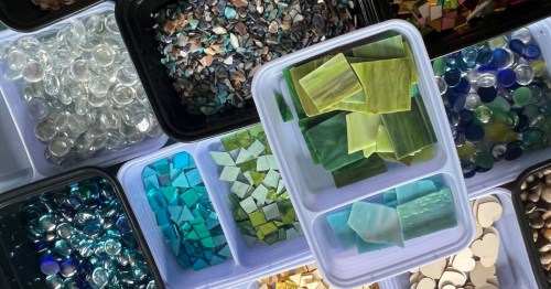Cut glass pieces and glass baubles in different colors organized in containers at Lake Geneva Art Studio in Lake Geneva, Wisconsin.