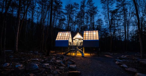 Exterior of Glo Pod Airbnb in West Virginia, illuminated to look like a lantern, with dark trees in the background