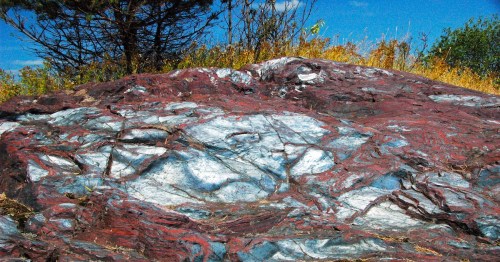 Detailed view of swirled red jasper and silver hematite layers at Jasper Knob in Ishpeming, Michigan.