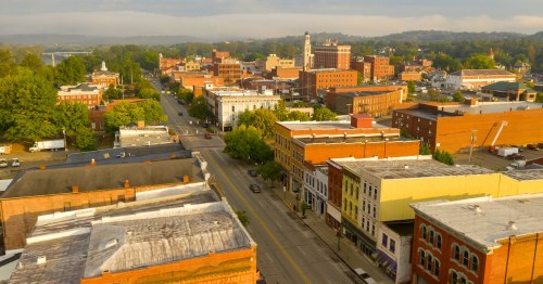 Aerial view of historic downtown Marietta, Ohio, featuring Victorian-era brick buildings and tree-lined streets.