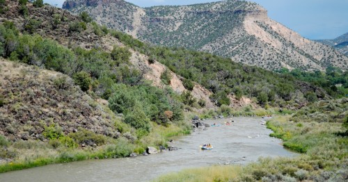 people rafting down the rio grande surrounded by mountains in pilar, new exico