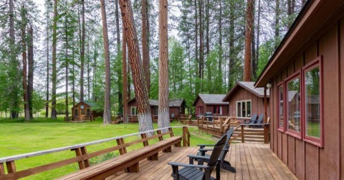Picturesque, historic cabins perched near a creek near Sisters, OR, surrounded by tall pines