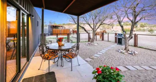Outdoor patio area at Desert Sunrise, an Airbnb in Wickenburg, AZ, surrounded by gravel, and a horse next to a fence.